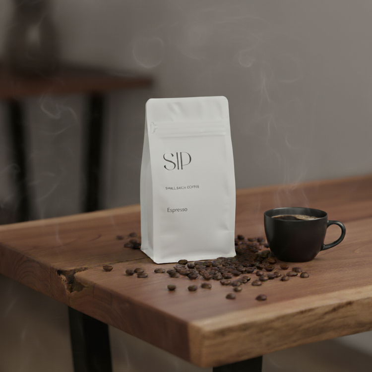White coffee bag labeled 'SIP' with a steaming black cup and scattered coffee beans on a wooden surface.